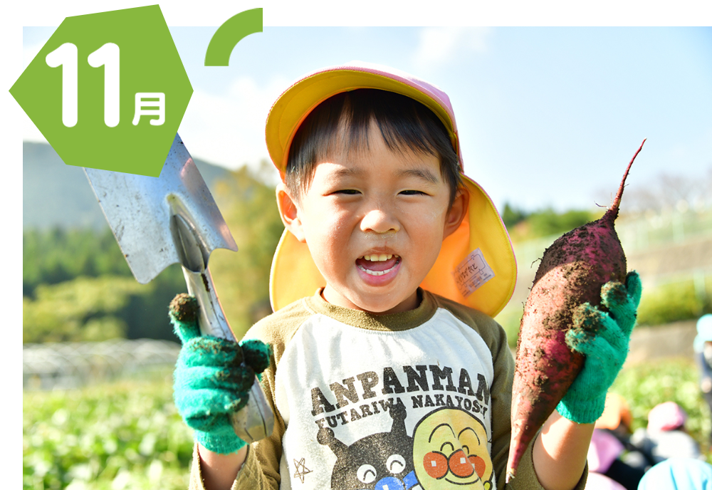 スコップと芋を持つ男の子